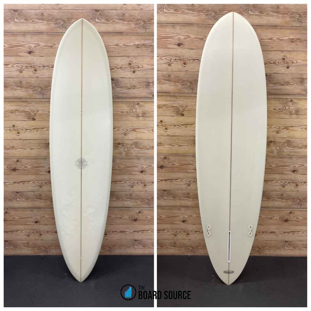 A used Seraph Pintail surfboard, 7'0" in length, shown in great condition with minor cosmetic wear. The image displays the surfboard from both the top and bottom views, revealing a pale color and a light-colored deck with a small light cosmetic crack on the nose.